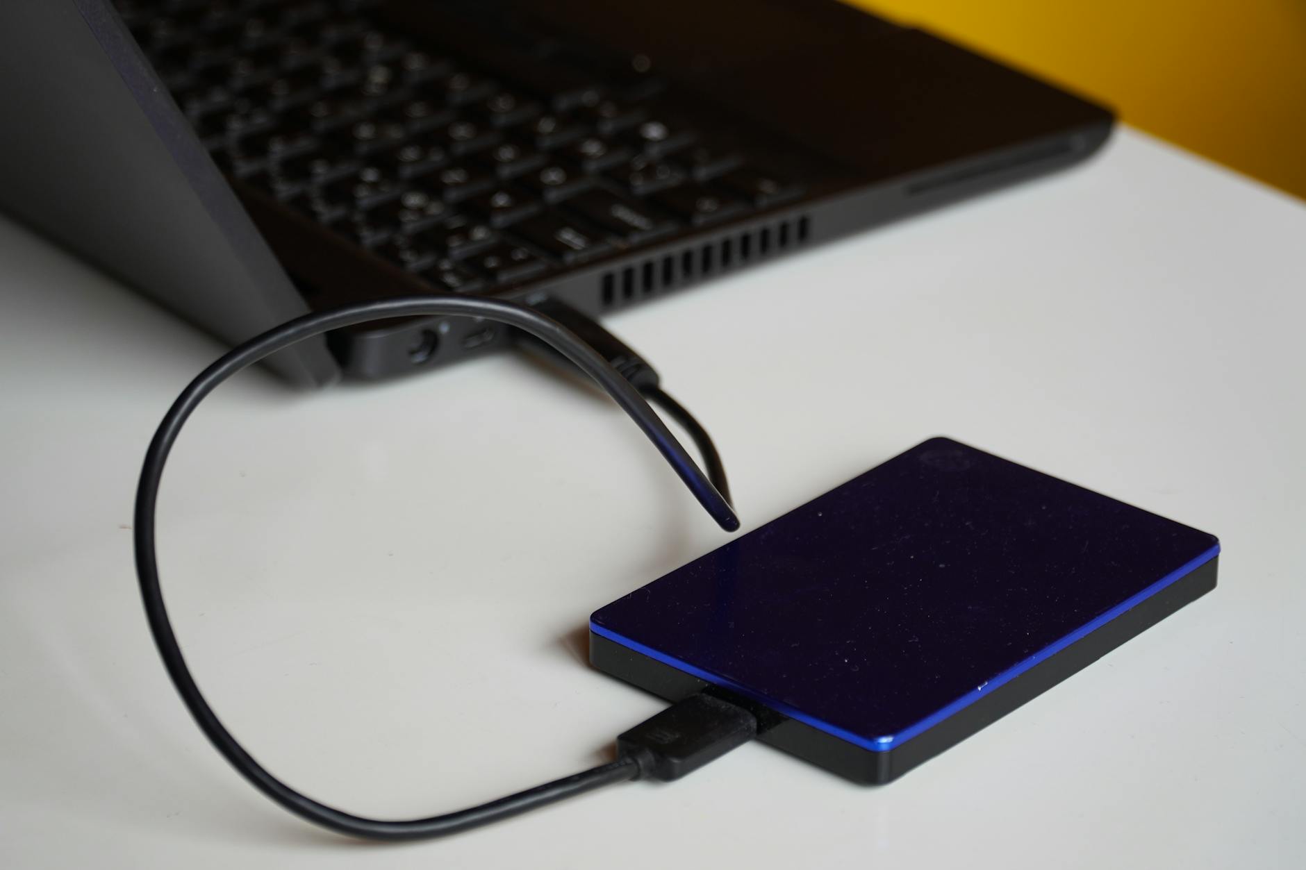 External hard drive connected to a laptop for local photo storage and backup
