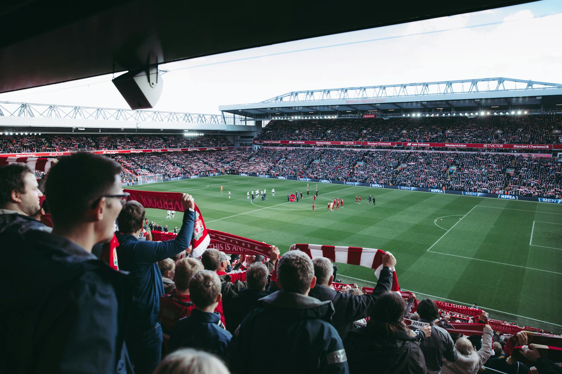 Energetic football fans cheering together in a packed stadium