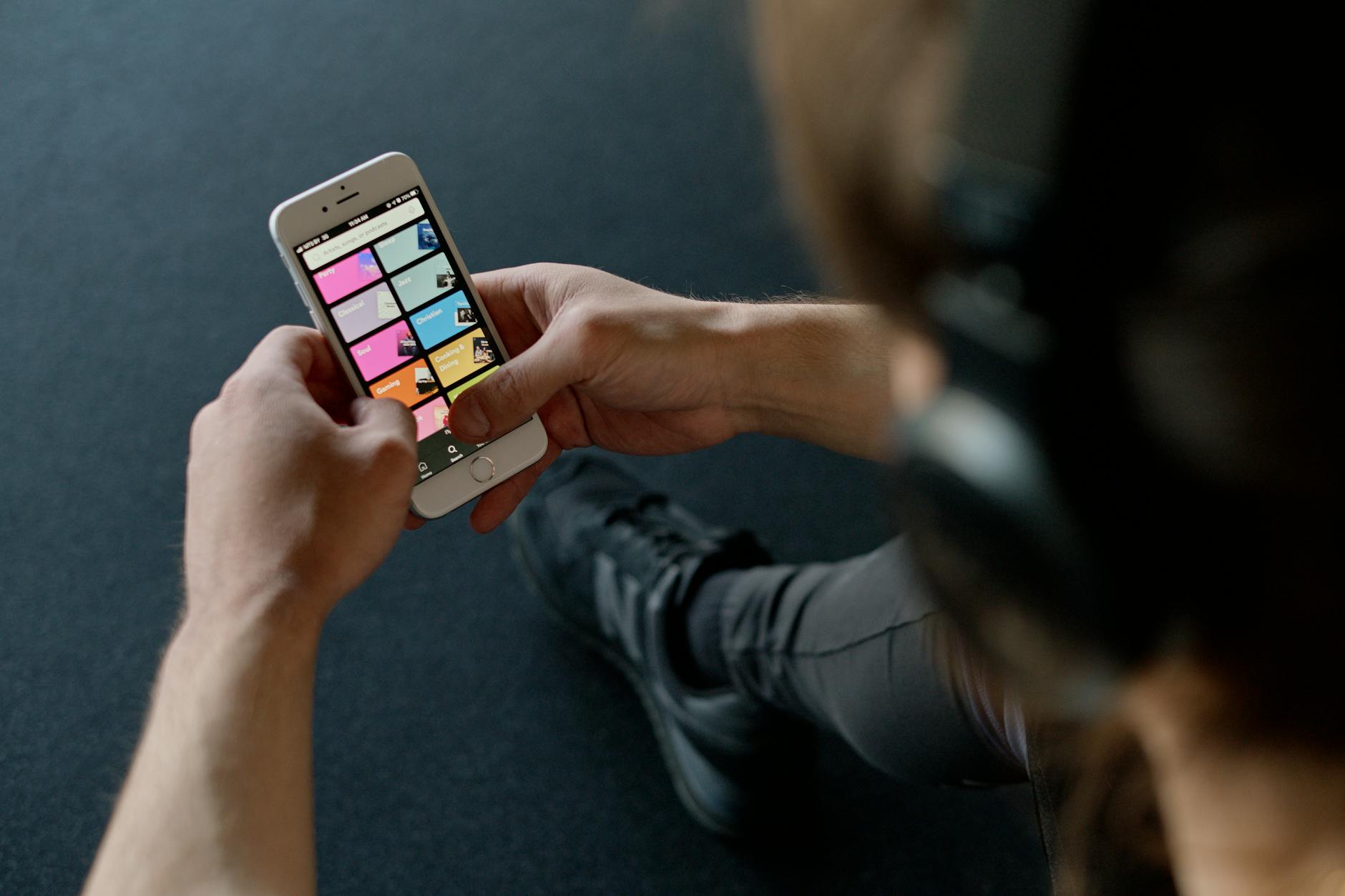 Person checking smartphone with music streaming playlist running at the gym