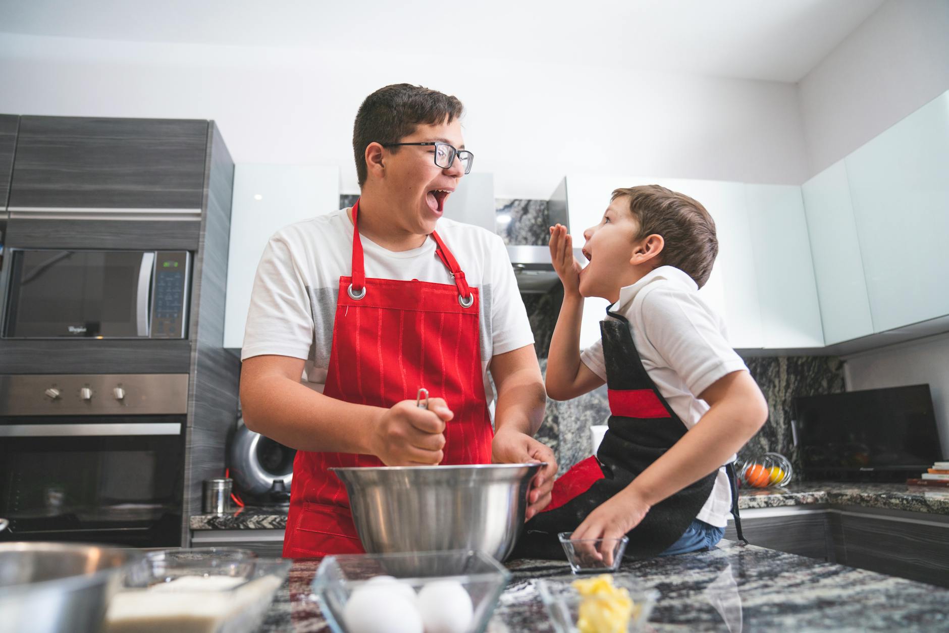 Father and son cooking together safely in a modern kitchen