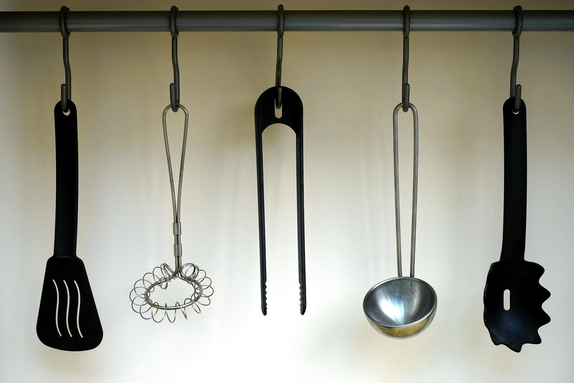 Kitchen Utensils Hanging Rail Storage Kitchen utensils hanging on a wall-mounted rail for easy access