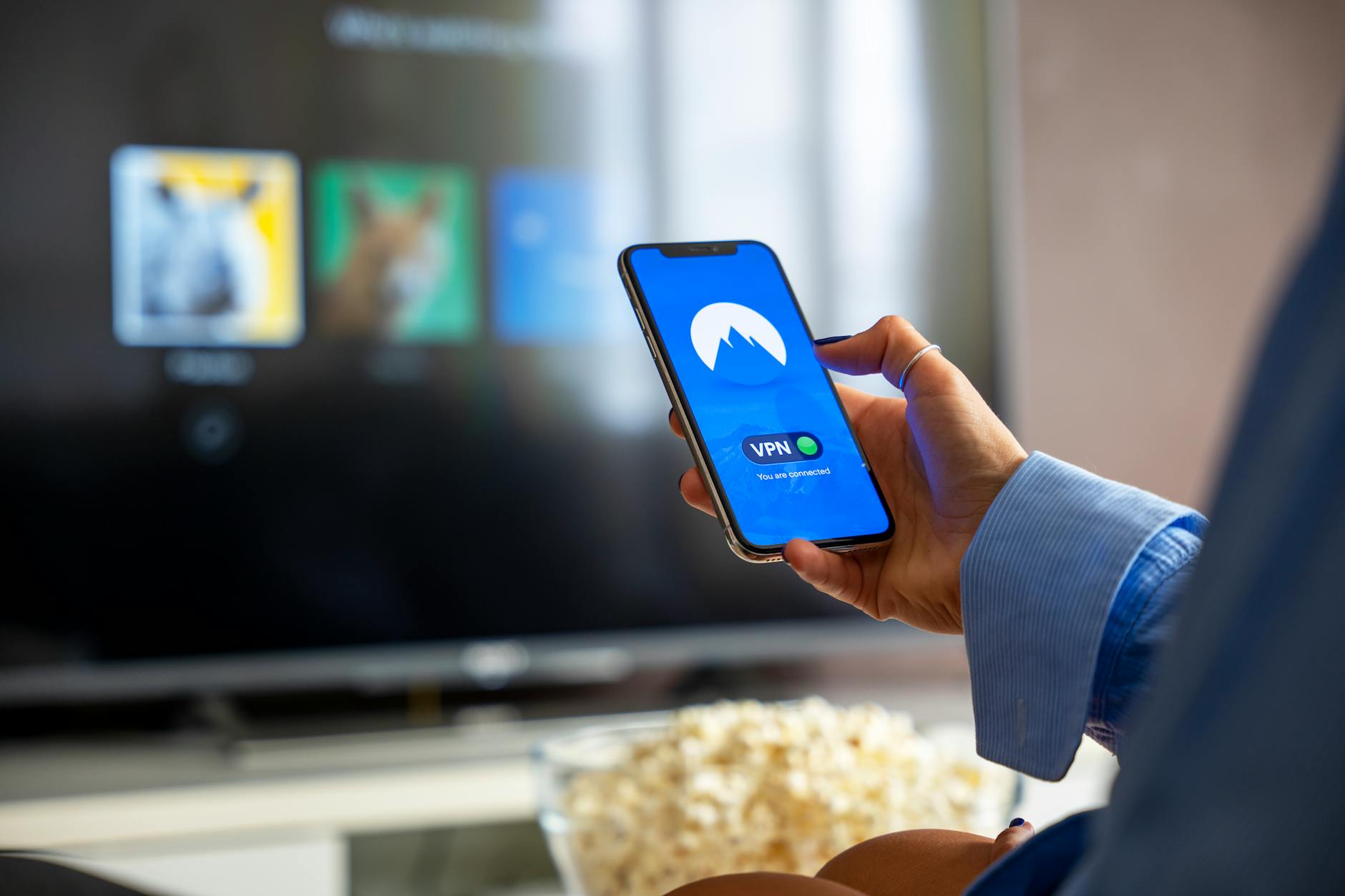 How to stream March Madness on phone without killing battery Person streaming sports on a smartphone while watching on TV