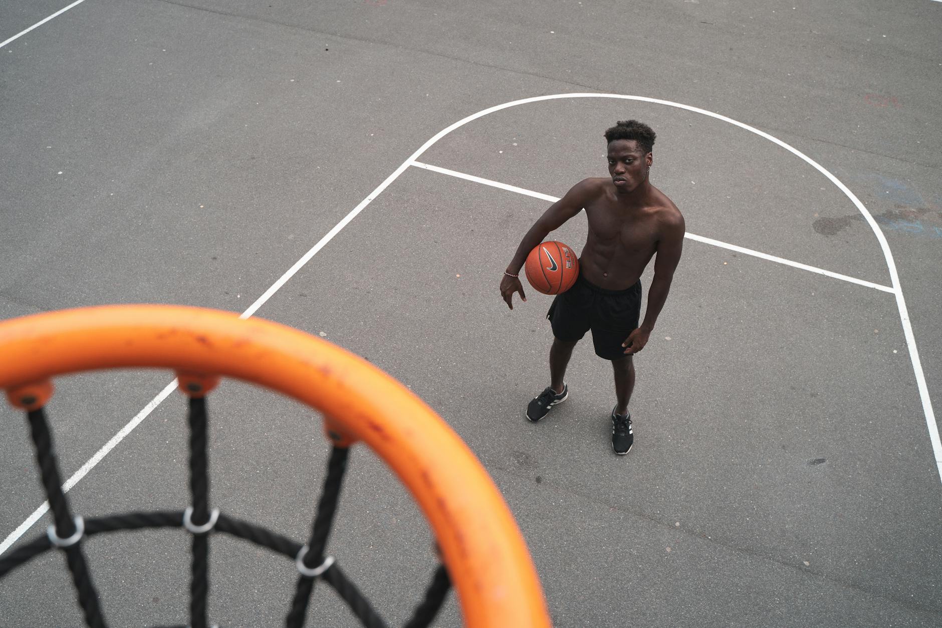 International Fans Following March Madness 2026 Basketball player with the ball on an outdoor court, viewed from above