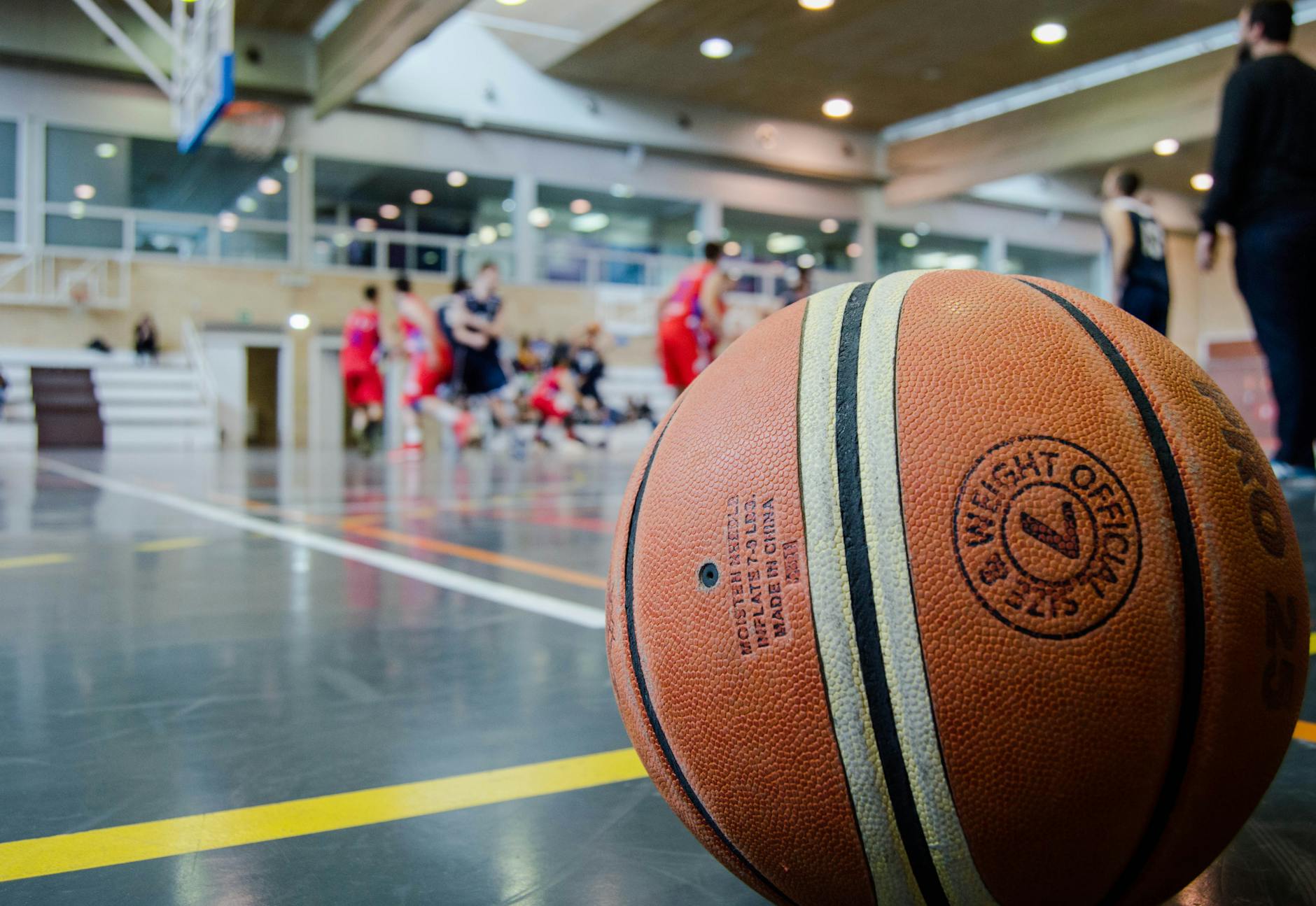March Madness Fan Travel Guide 2026 Indoor basketball game with fans in the stands during a tournament atmosphere