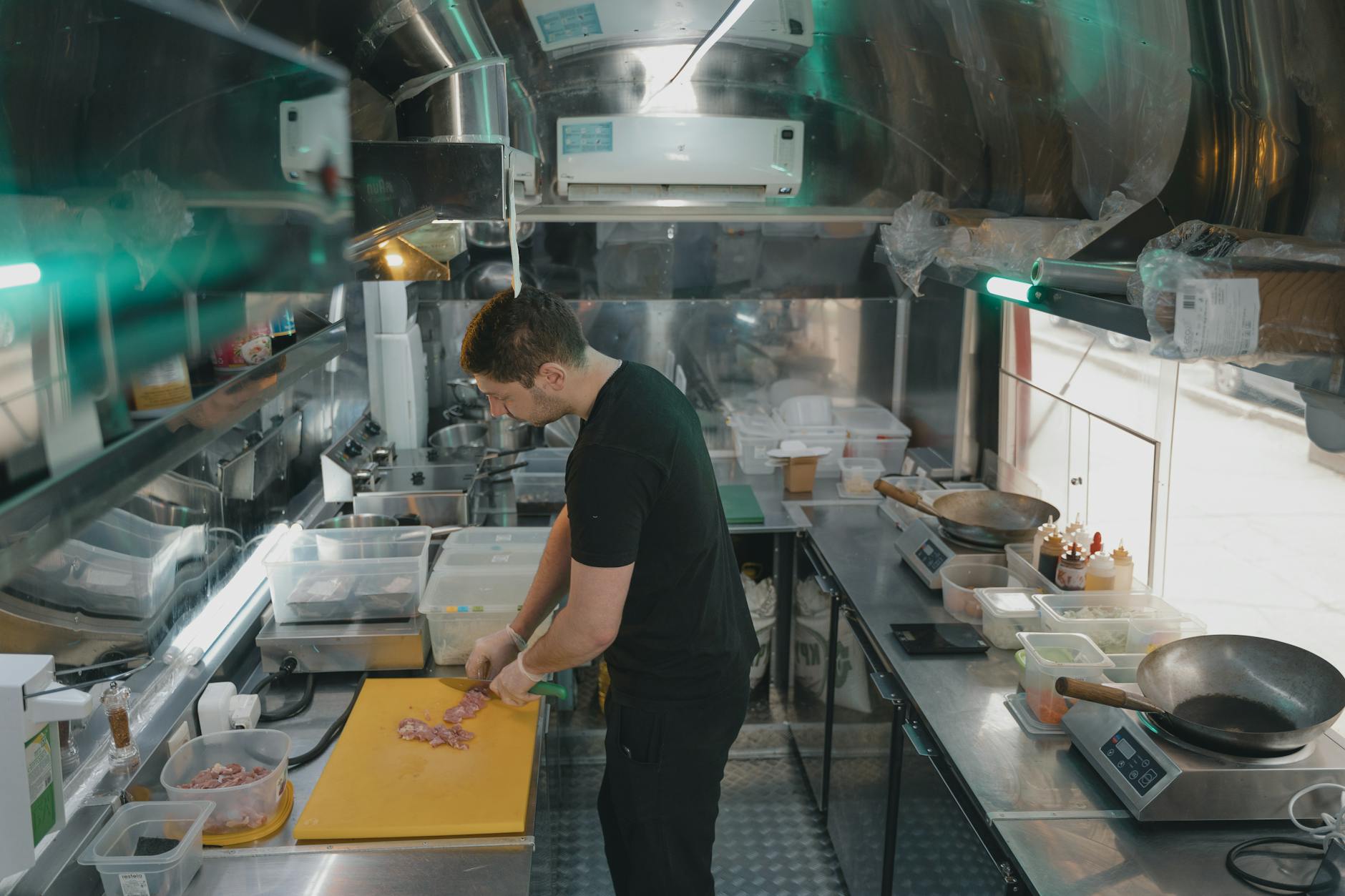 Chef slicing ingredients on a yellow plastic cutting board in a professional kitchen