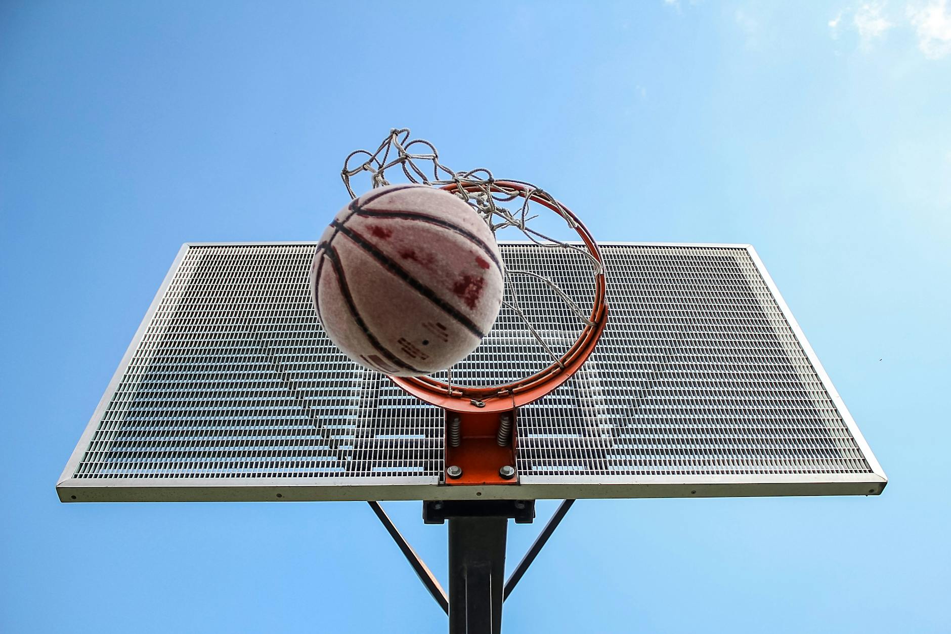 Basketball Scoring Through the Hoop NBA Rules Basketball going through the hoop against a clear blue sky — the goal of every NBA possession