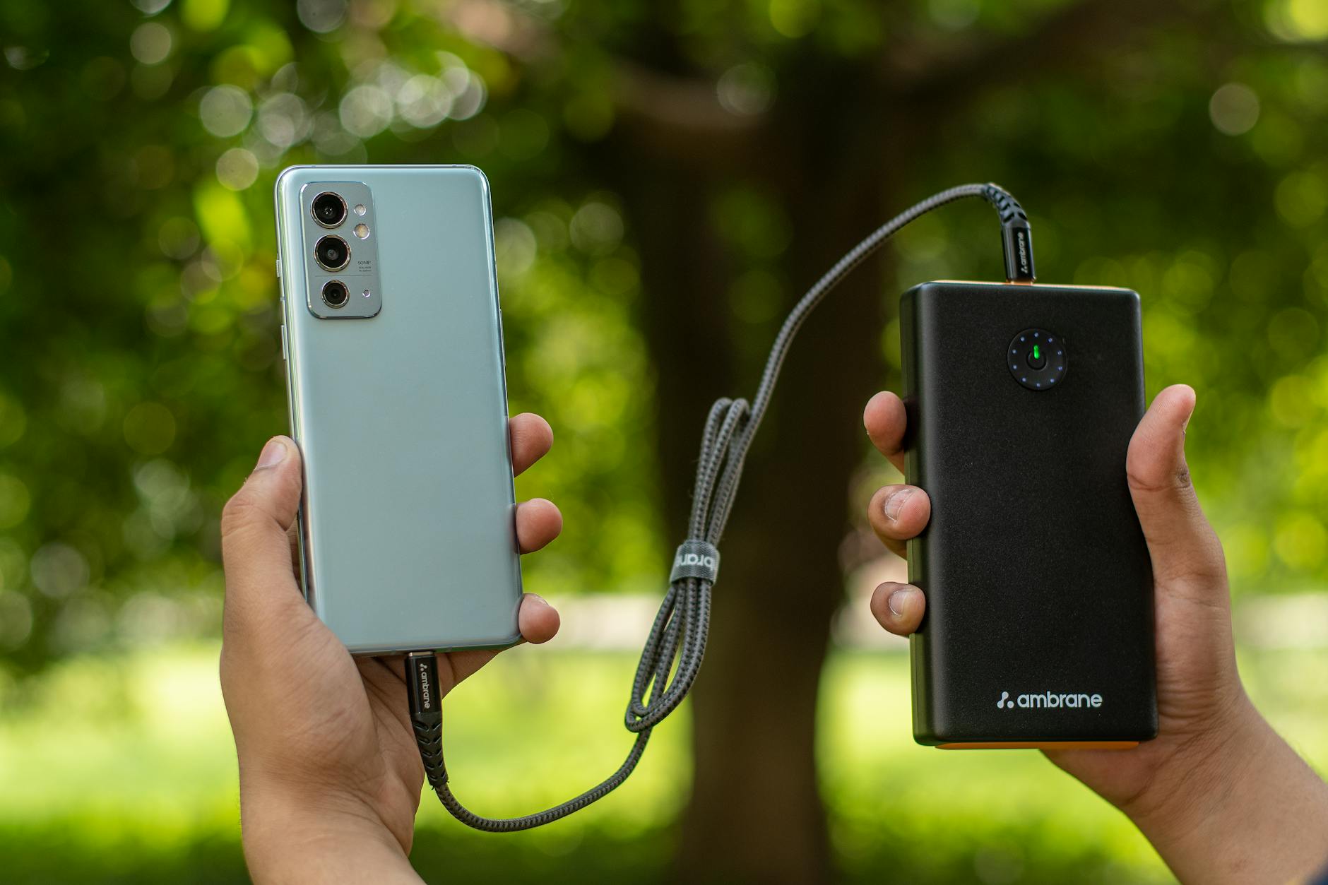 Power Bank Portable Charger for NBA Games Hands holding a smartphone connected to a power bank for charging