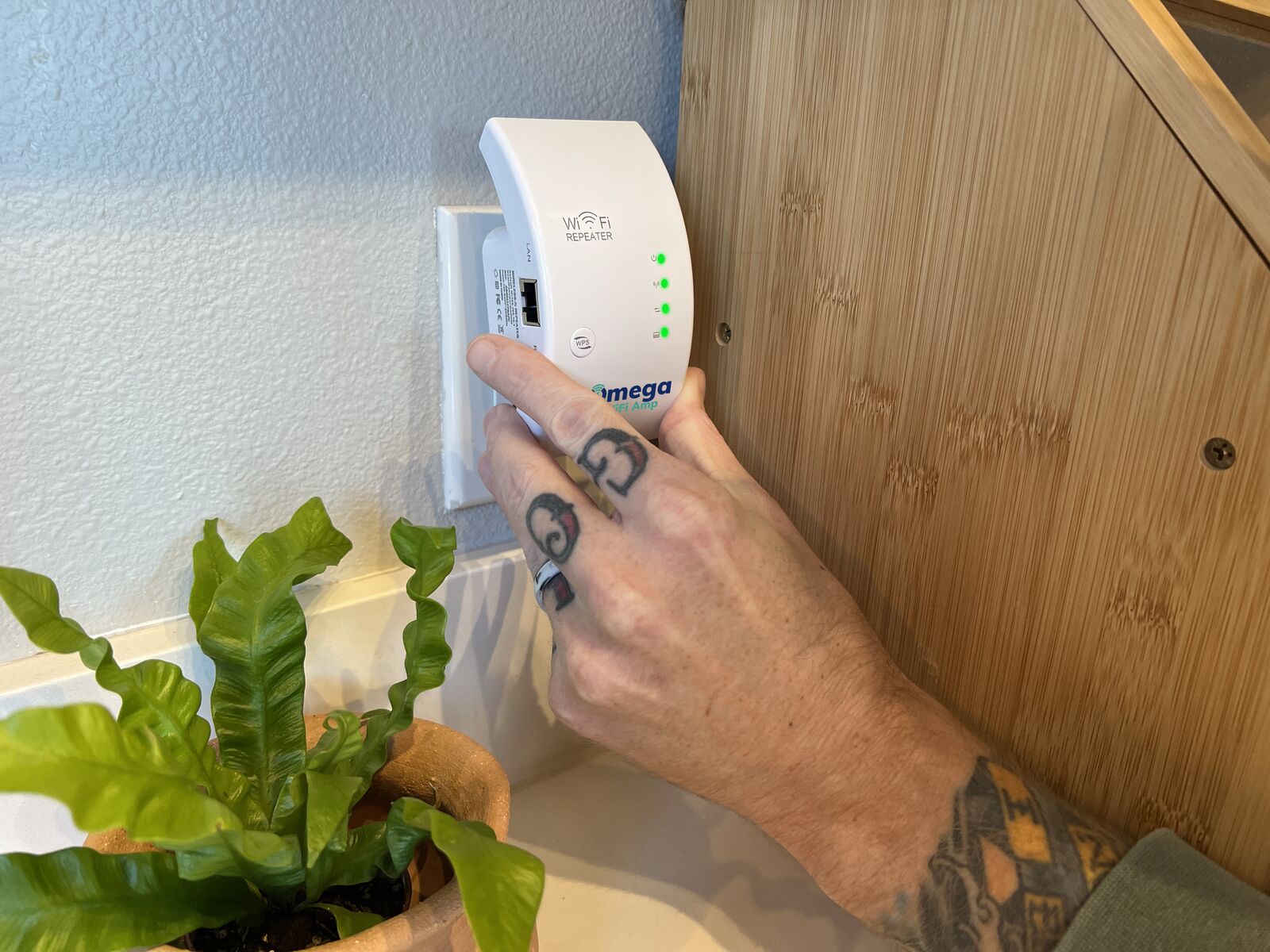 Omega WiFi Amp being plugged into a wall outlet demonstrating the simple plug-in installation process