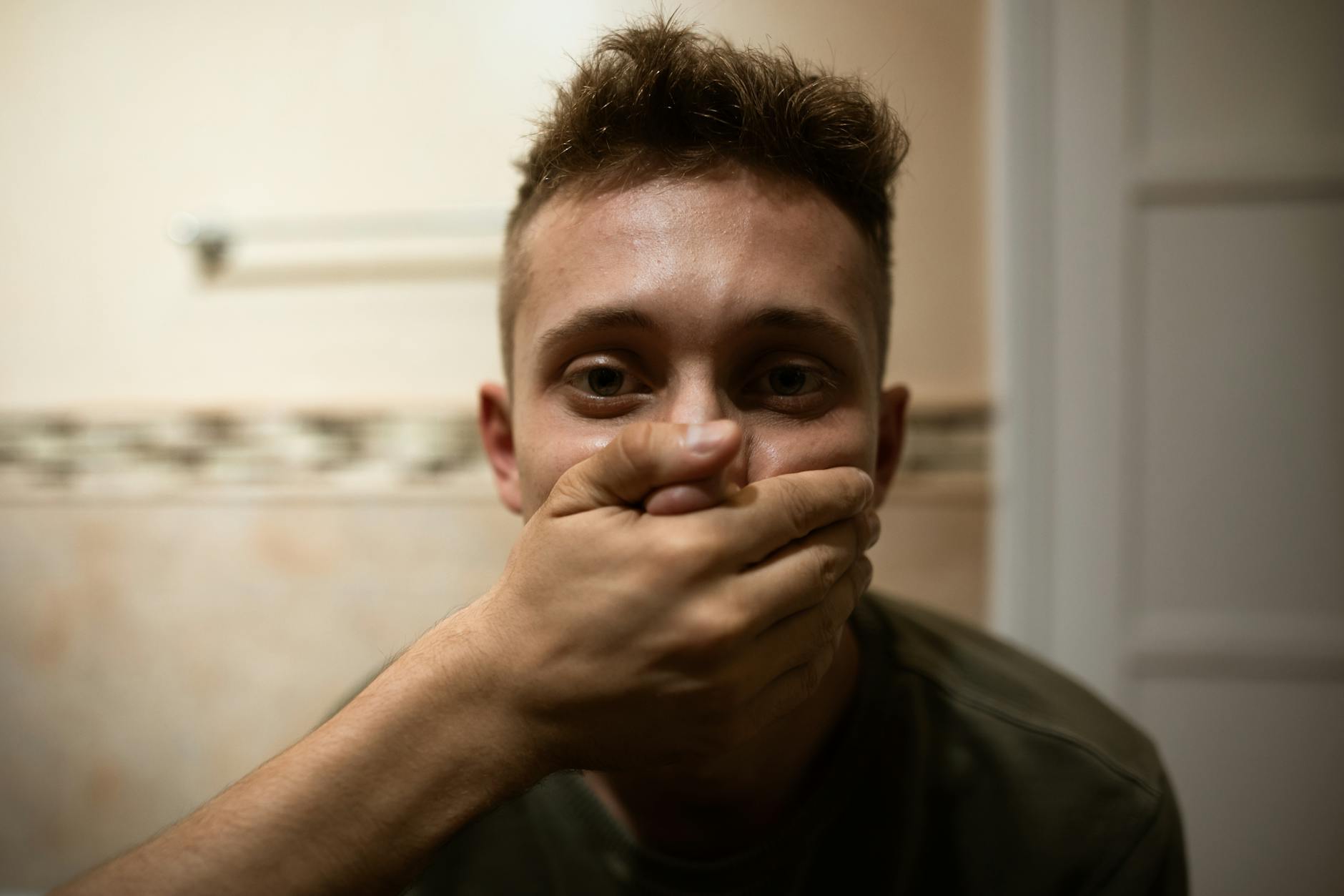 Oral Fixation Behavioral Habit - Hand to Mouth Pattern Young man with hand over mouth reflecting on behavioral habits and oral fixation