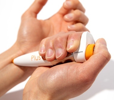 Paingone Plus TENS pen being applied to the wrist area for pain relief