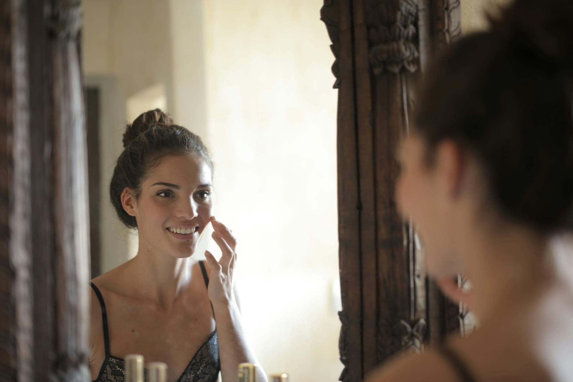 Young woman looking confidently at her reflection in a mirror