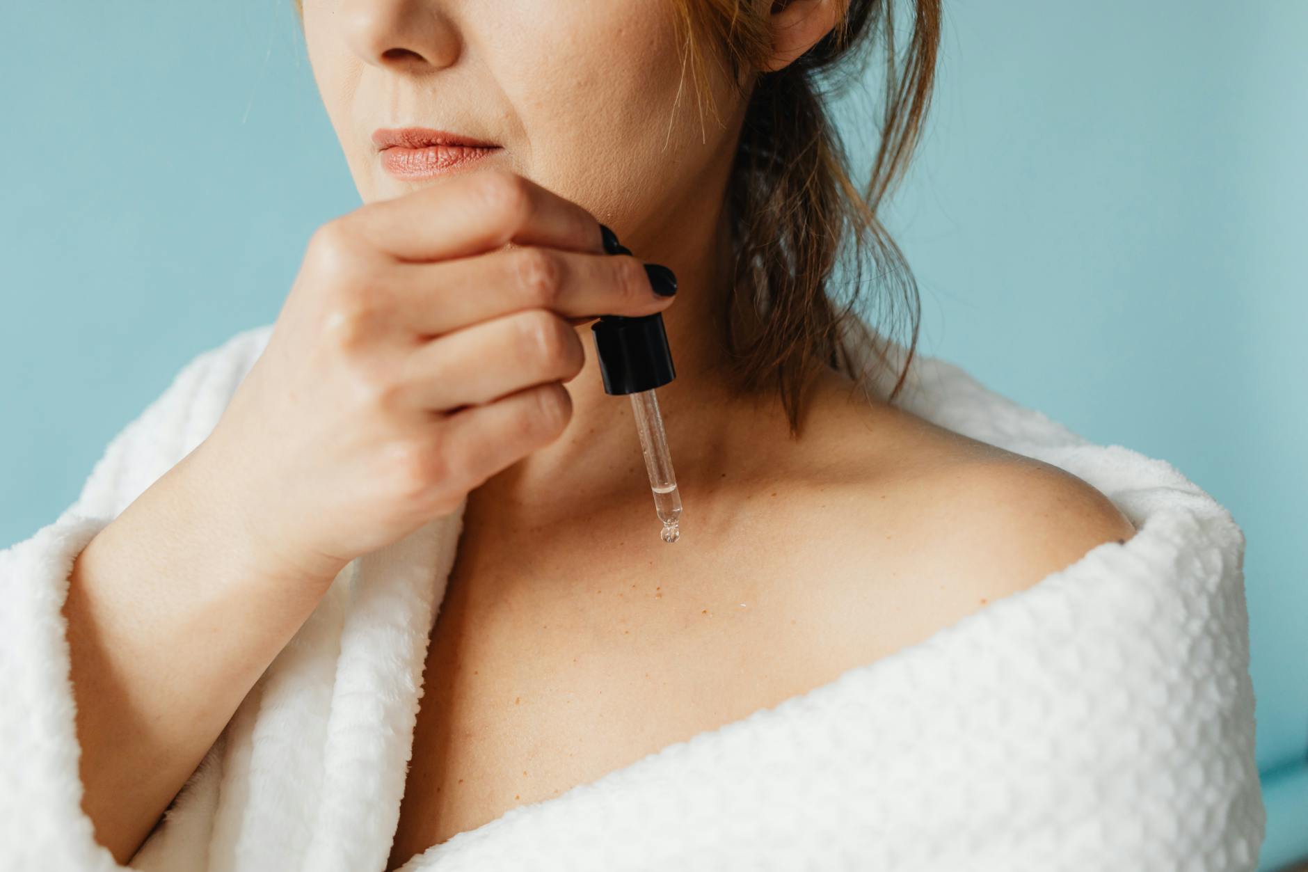 Skincare routine after peach fuzz removal for best results Woman applying skincare serum as part of a facial care routine