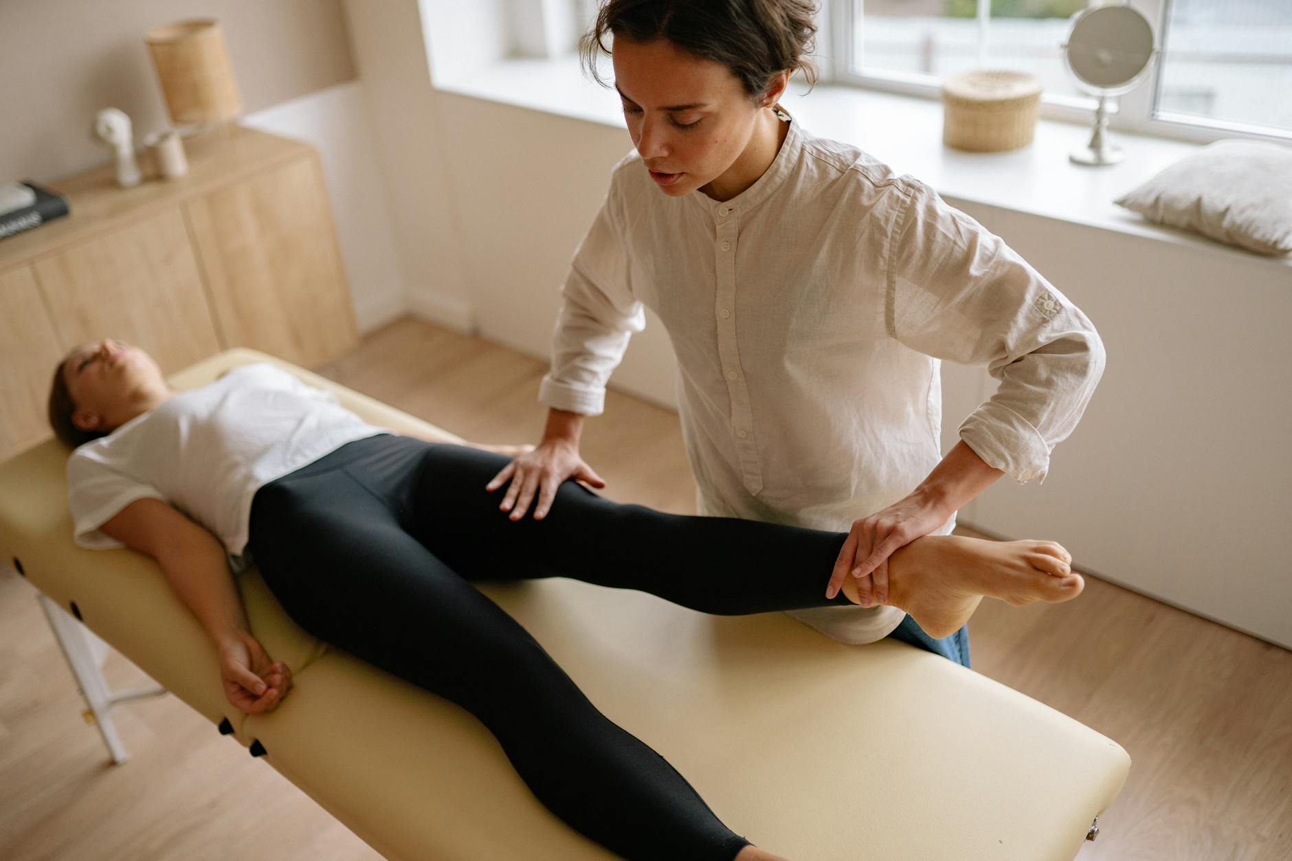 Physical Therapy for Peripheral Neuropathy Rehabilitation A physiotherapist assisting a patient with leg rehabilitation exercises for nerve recovery