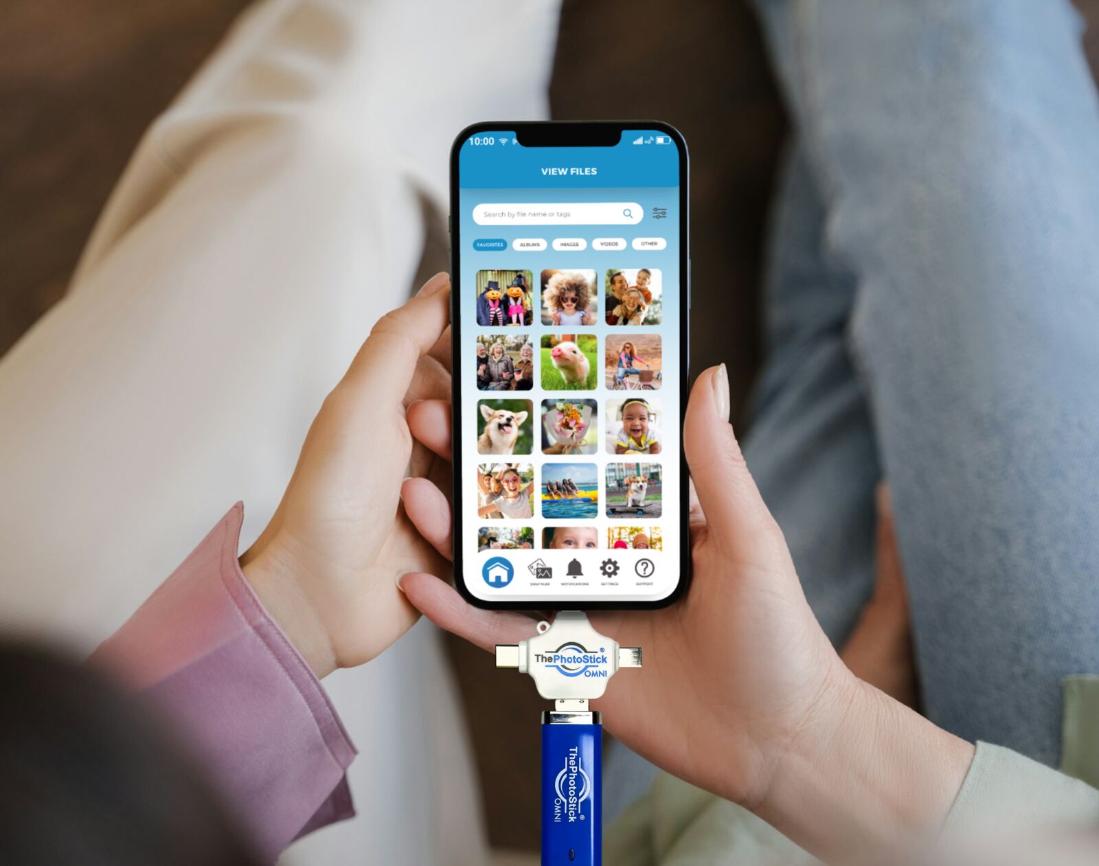 ThePhotoStick Omni connected to a smartphone showing backup in progress