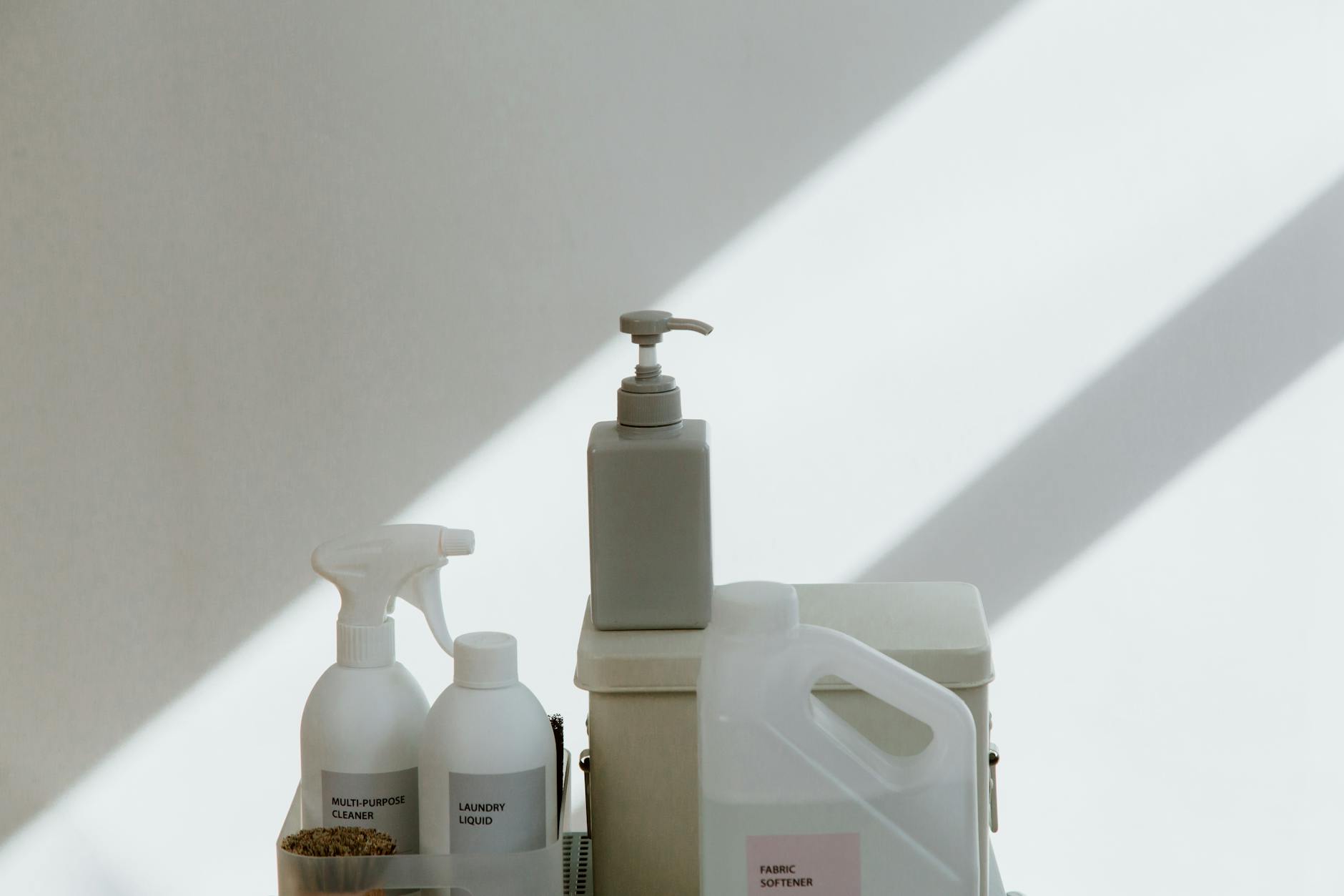 A clean collection of household cleaning products arranged against a minimal background