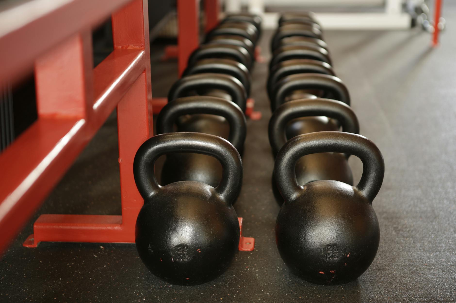Kettlebells and free weights lined up in a gym — Planet Fitness offers dumbbells up to 75 lbs but no barbells or squat racks