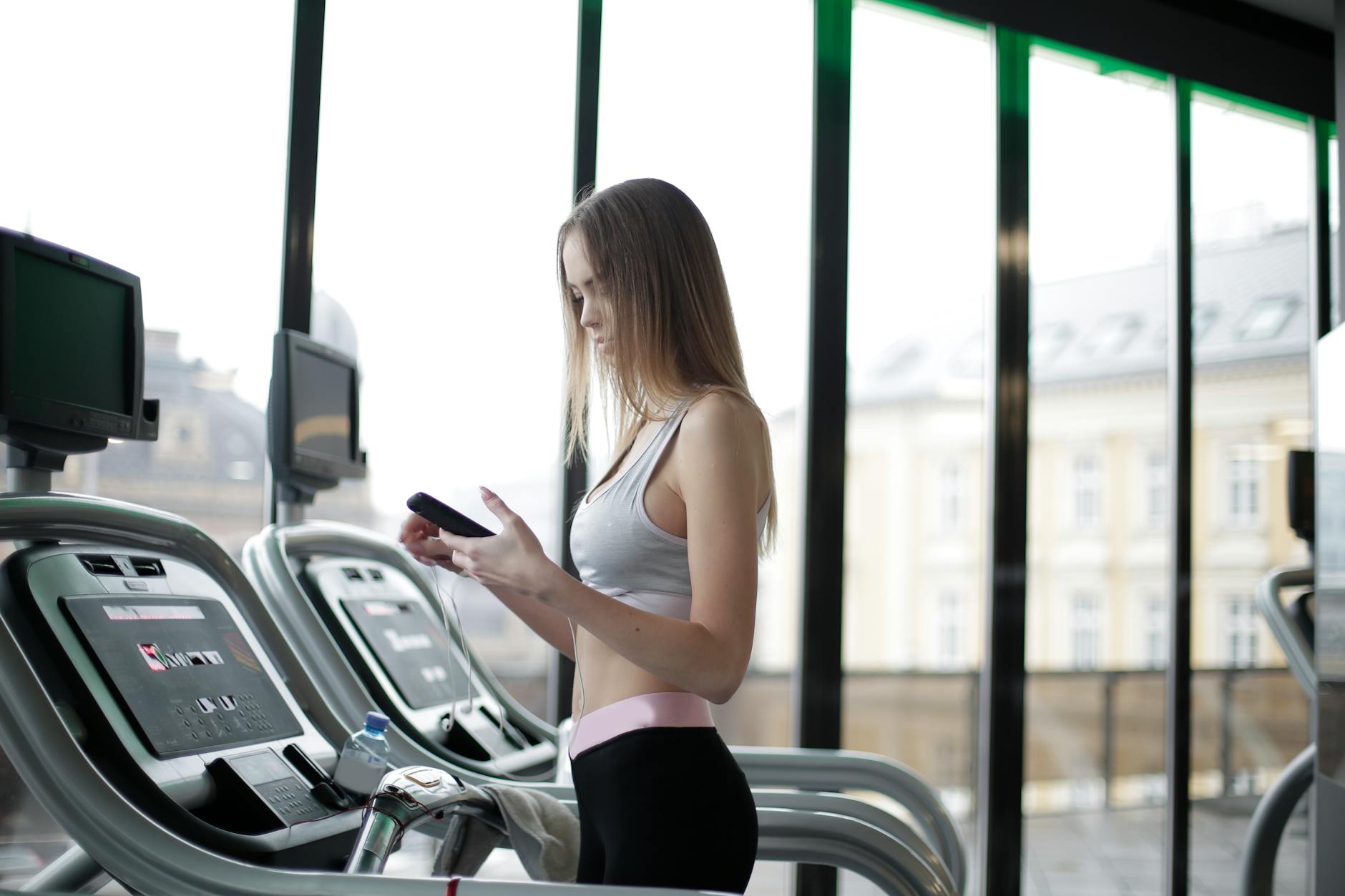 Woman using a treadmill at the gym — cardio machines are the centerpiece of Planet Fitness locations