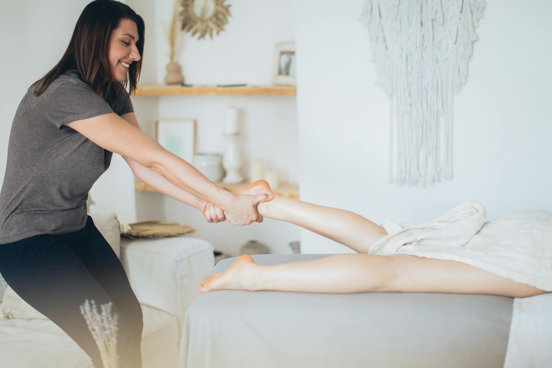 Therapist giving a foot massage in a spa setting to promote circulation and relaxation