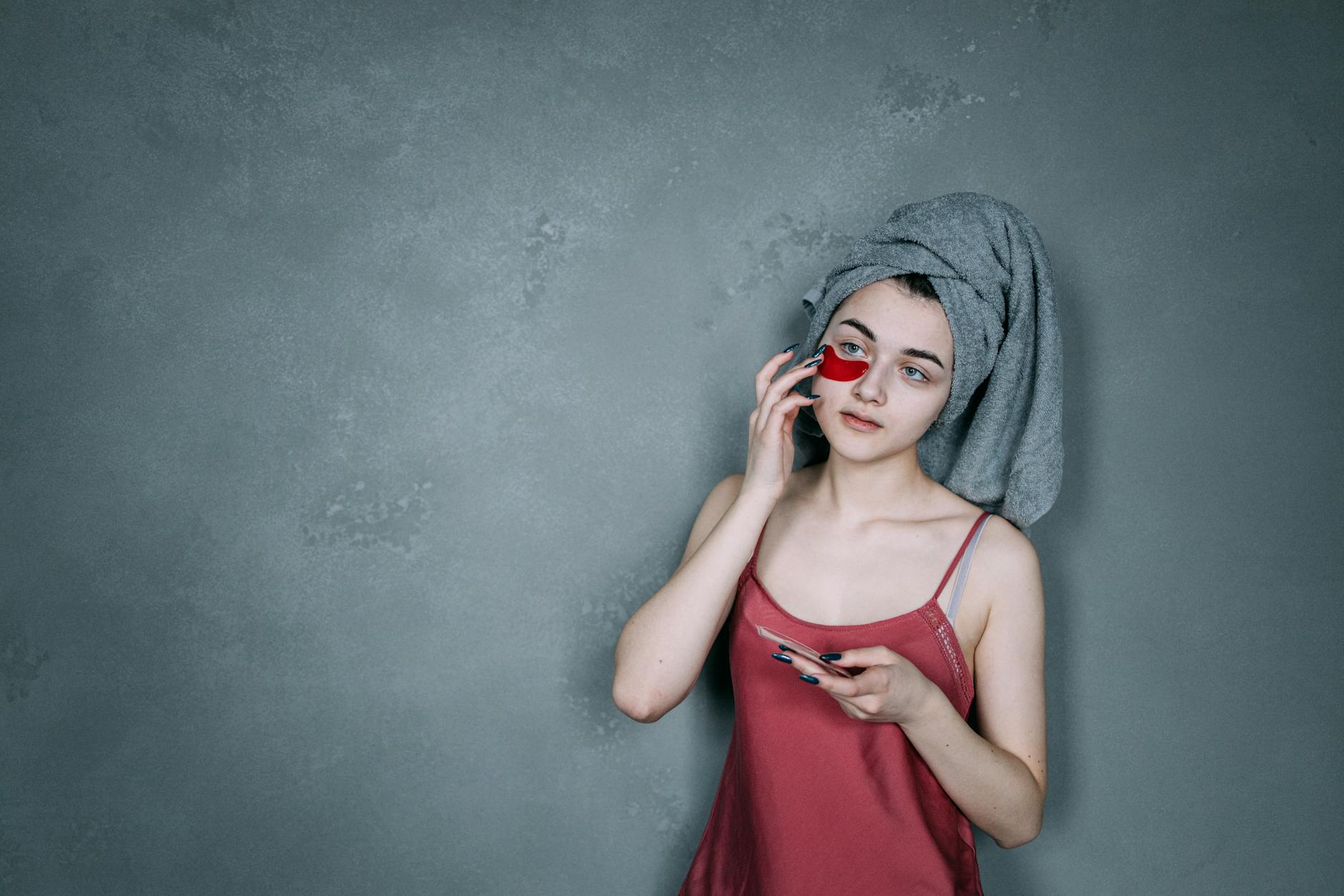 Woman applying under-eye patches as part of a morning skincare routine to reduce puffiness