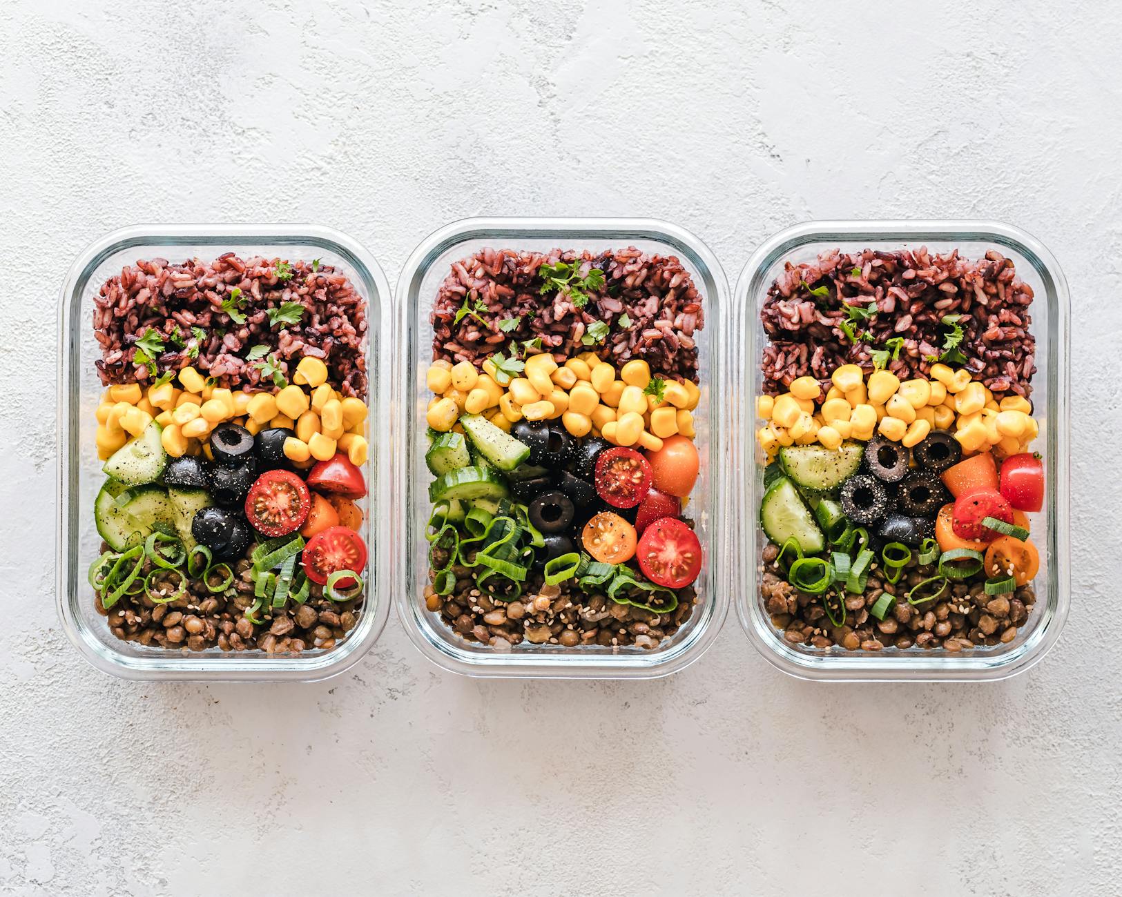 Healthy meal prep with vegetables and grains in glass containers — a great system for road trip snack organization