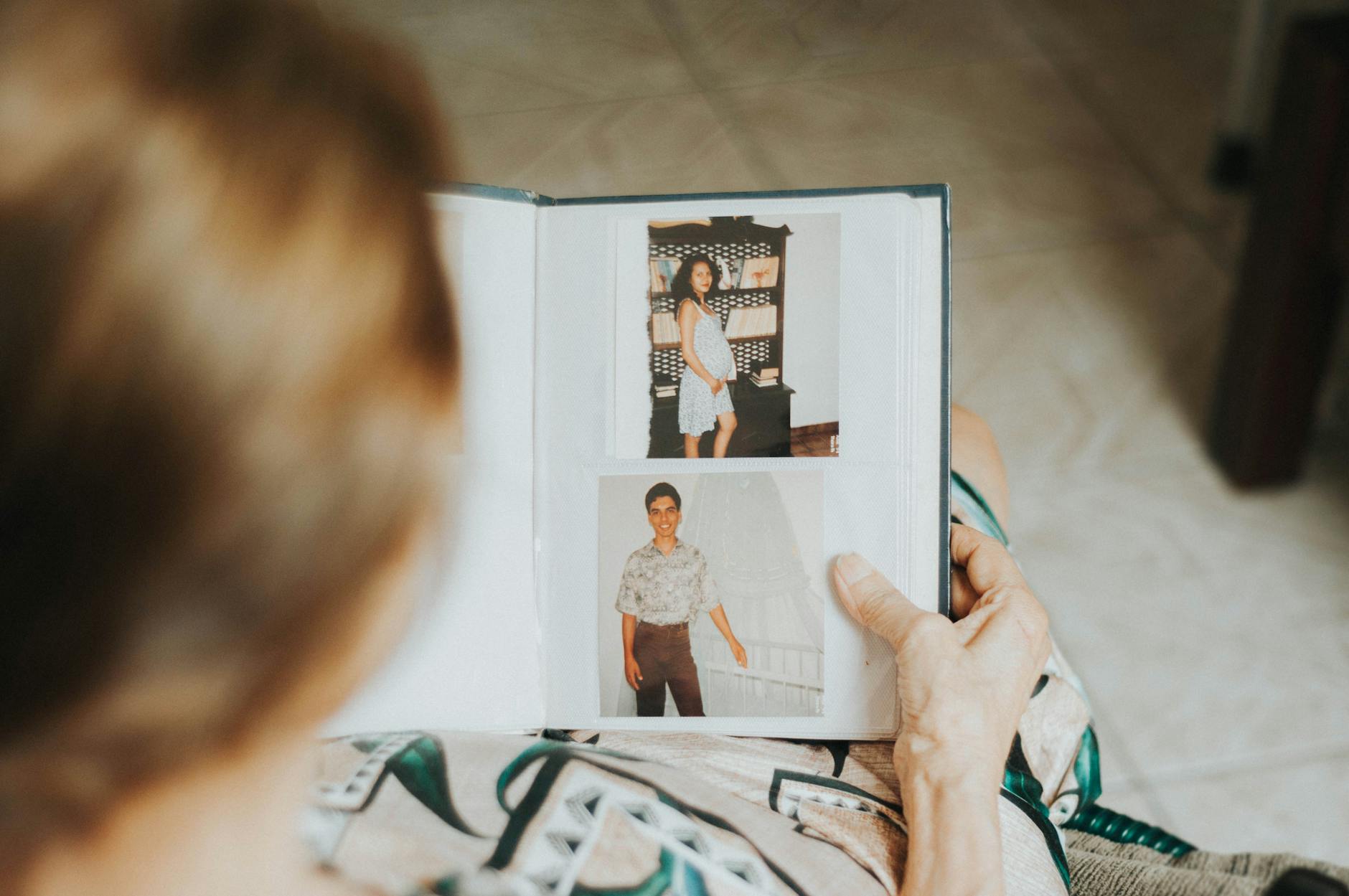 Senior woman looking through a photo album — connecting generations through shared family history and photographs