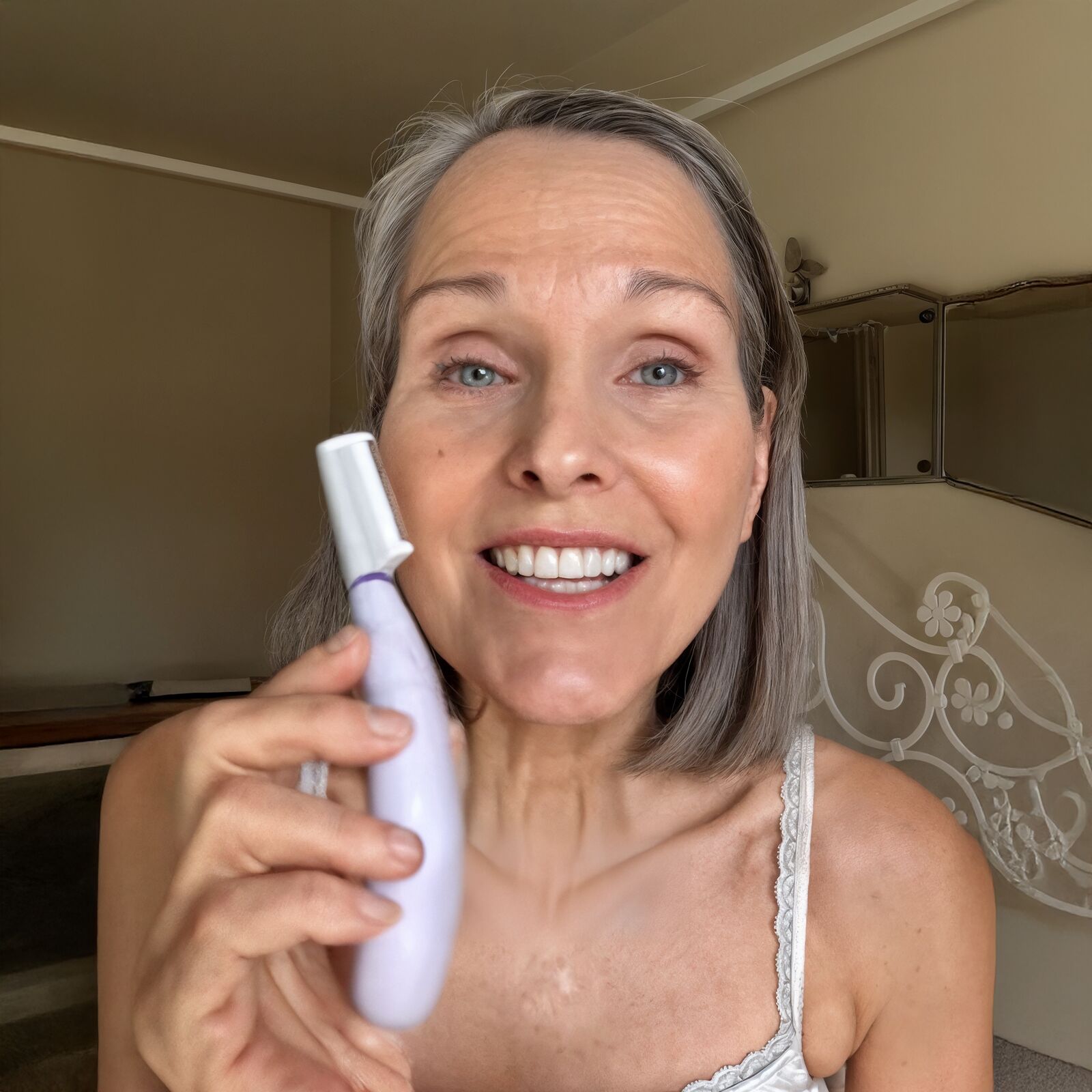 Woman using SonicSmooth Pro+ sonic dermaplaning device on her cheek