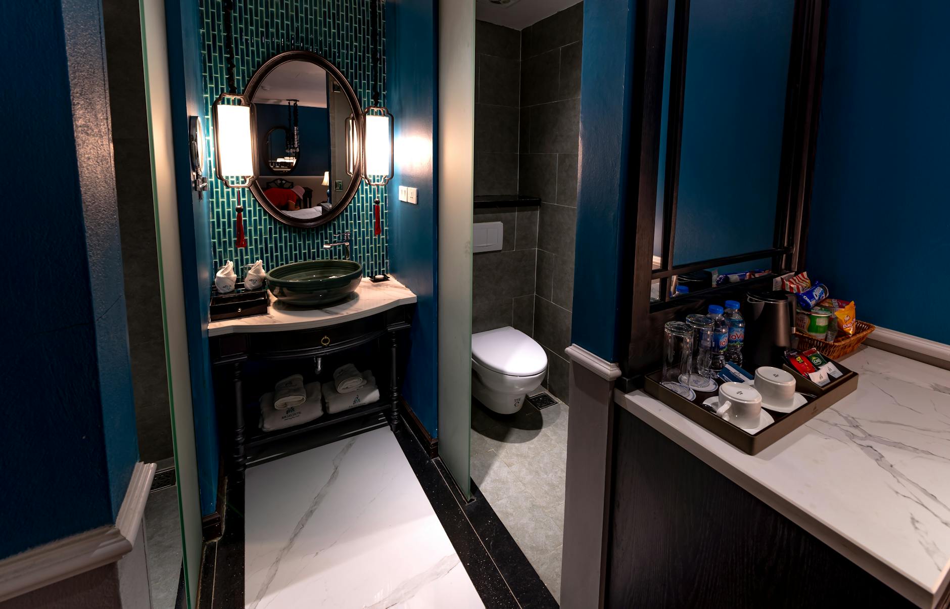 Modern hotel bathroom with blue walls and contemporary fixtures, illustrating typical travel hygiene risks