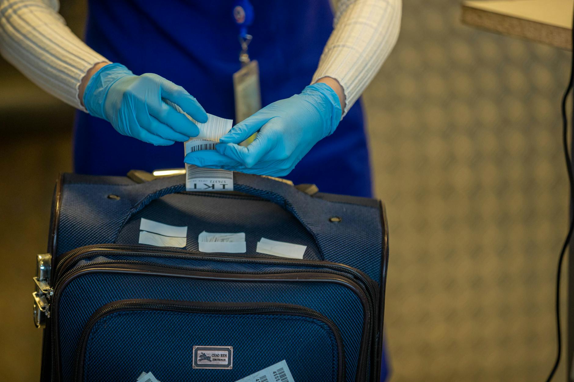 TSA Luggage Inspection Process Airport security officer inspecting luggage tags during baggage screening