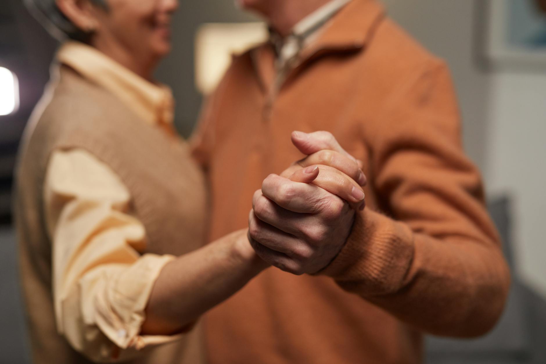 Senior couple sharing a warm moment together indoors, representing restored connection after addressing hearing loss