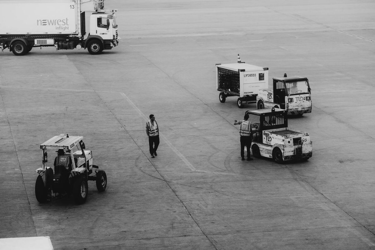 Airport Ground Operations Where Baggage Handling Occurs Airport ground crew and service vehicles on tarmac near aircraft