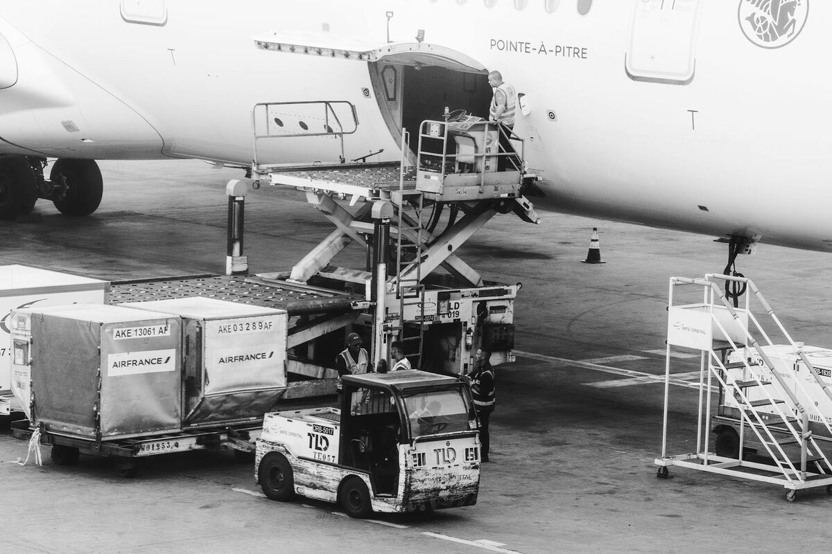 Baggage Being Loaded Into Aircraft Cargo Hold Ground crew loading cargo and checked baggage onto commercial airplane