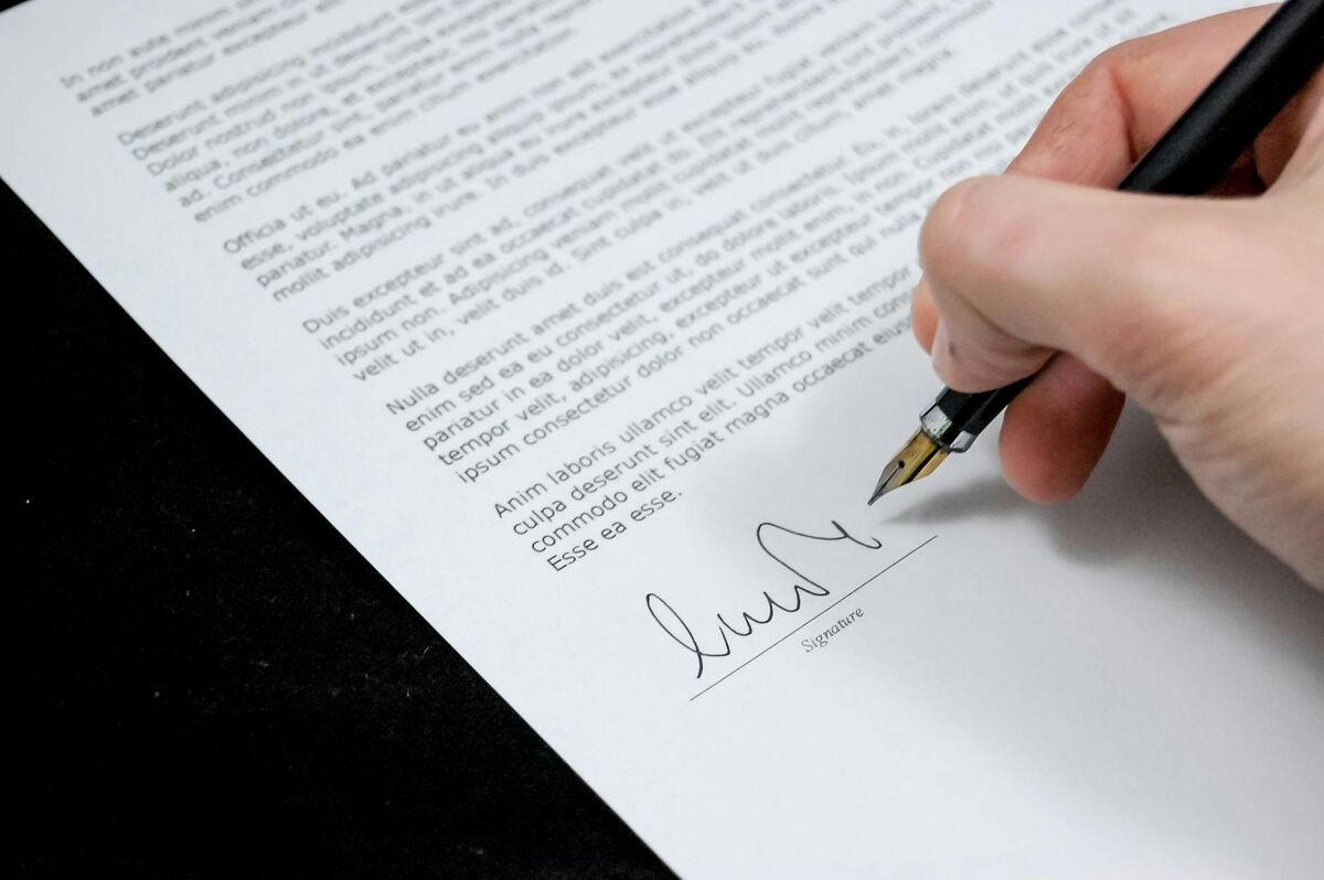 Legal Documents and Estate Administration After Death A person signing a legal document, representing the paperwork required in estate administration and probate