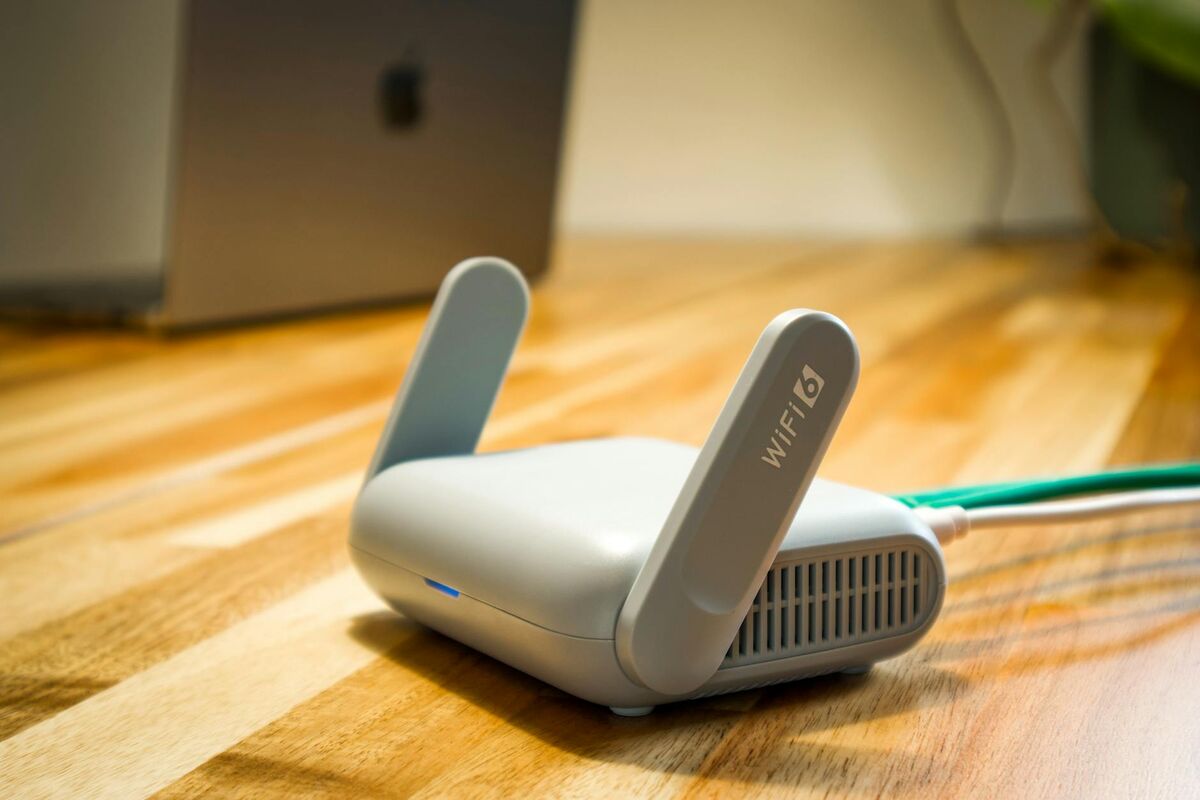 WiFi 6 router with antennas on a wooden desk representing home network security hardware