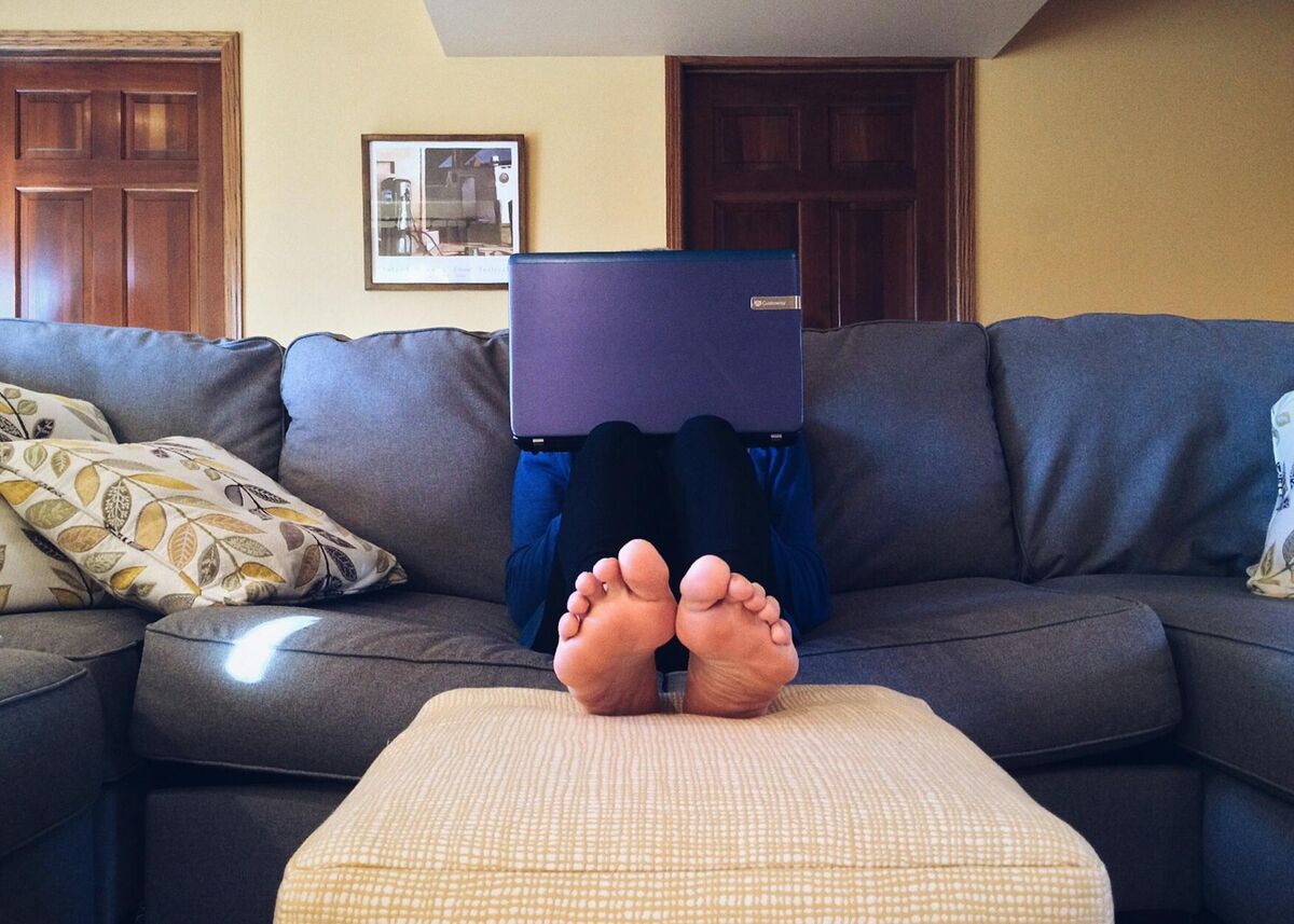 Leg Elevation for Foot and Ankle Swelling Relief Person resting on a couch with legs elevated to help relieve foot swelling