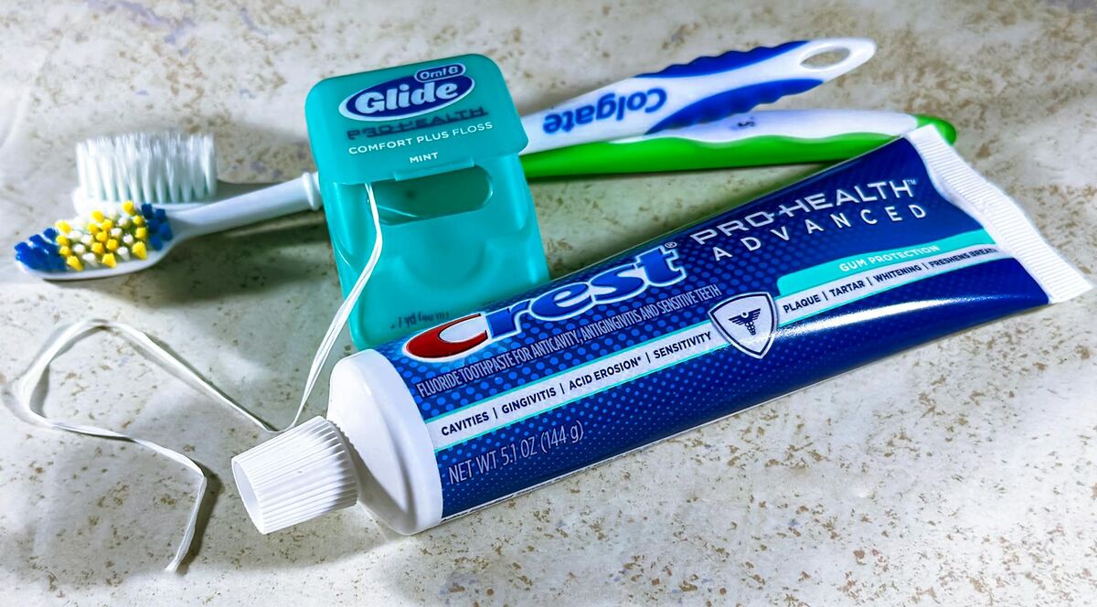 Essential Dental Care Tools for Healthy Gums 2026 Toothbrush, dental floss, and toothpaste arranged together — the three tools for preventing bleeding gums