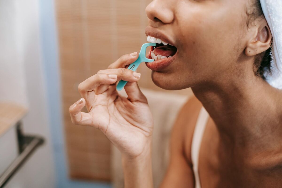 Daily Flossing for Gum Health Woman using dental floss as part of her daily oral hygiene routine