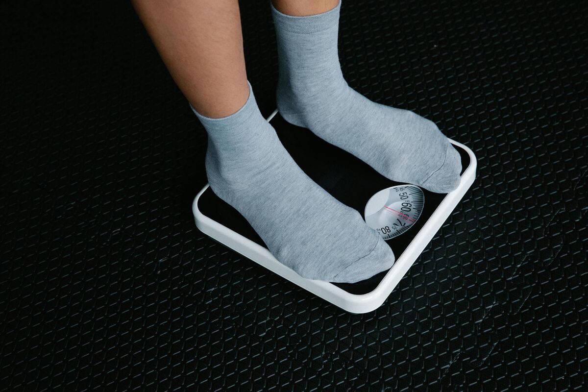 Feet in recovery socks on a scale — compression and recovery garments support circulation after standing all day