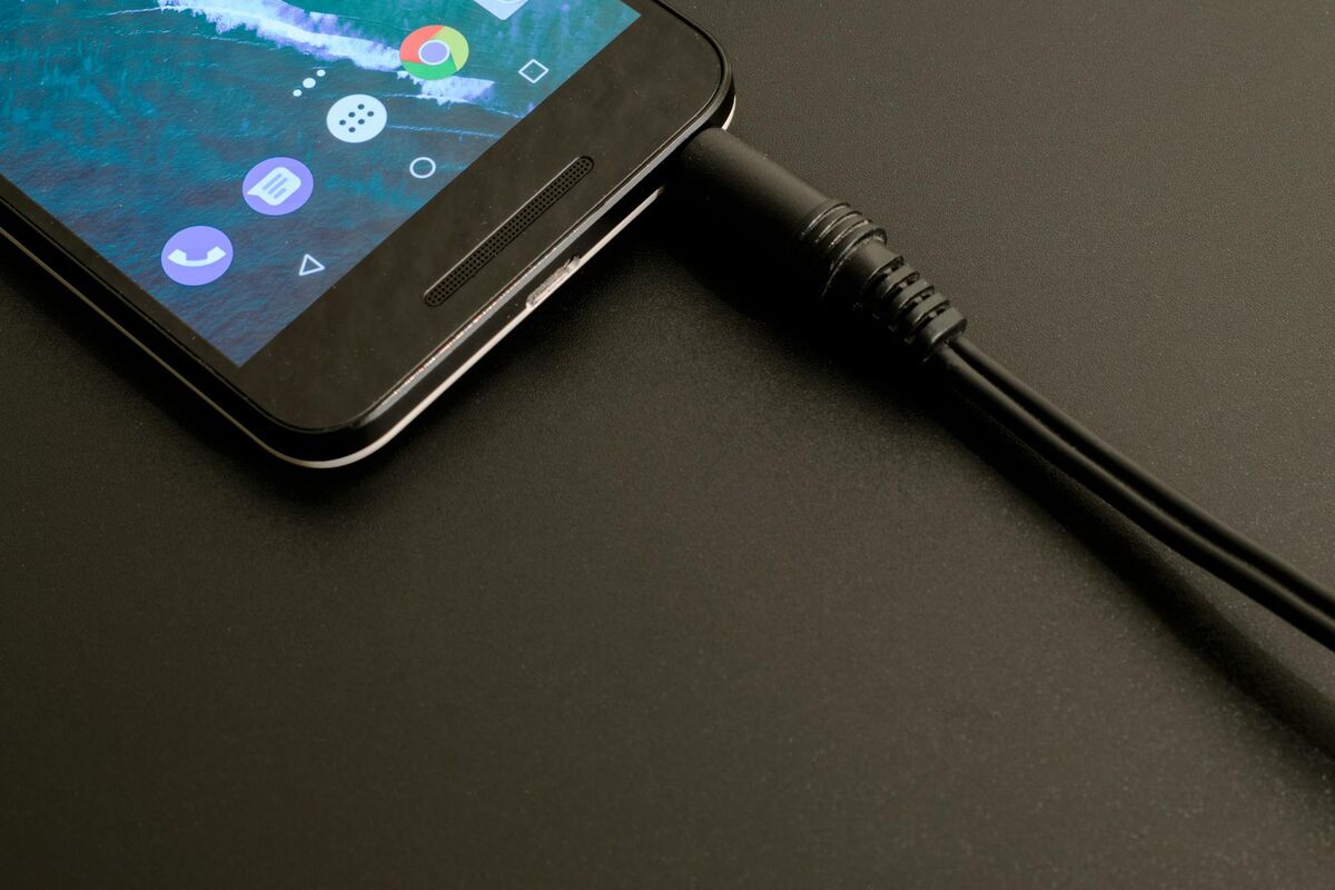 Smartphone Battery Charging — Lithium-Ion Technology Smartphone plugged in and charging, illustrating lithium-ion battery principles