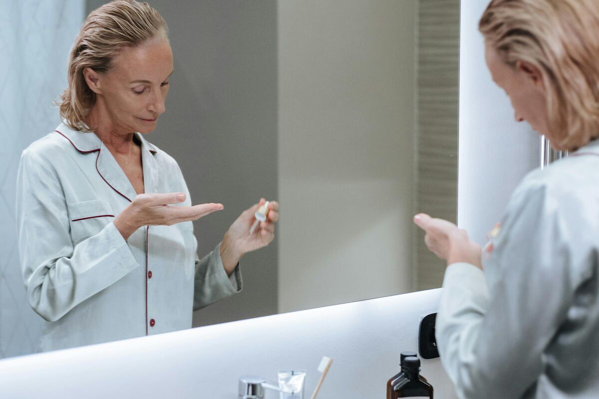 Senior woman applying skincare serum as part of her morning routine