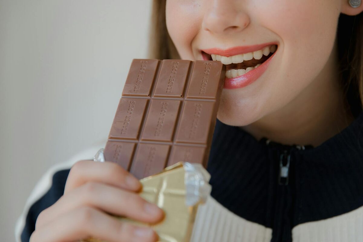 Everyday Triggers of Tooth Sensitivity Woman eating food, illustrating how everyday activities trigger tooth sensitivity