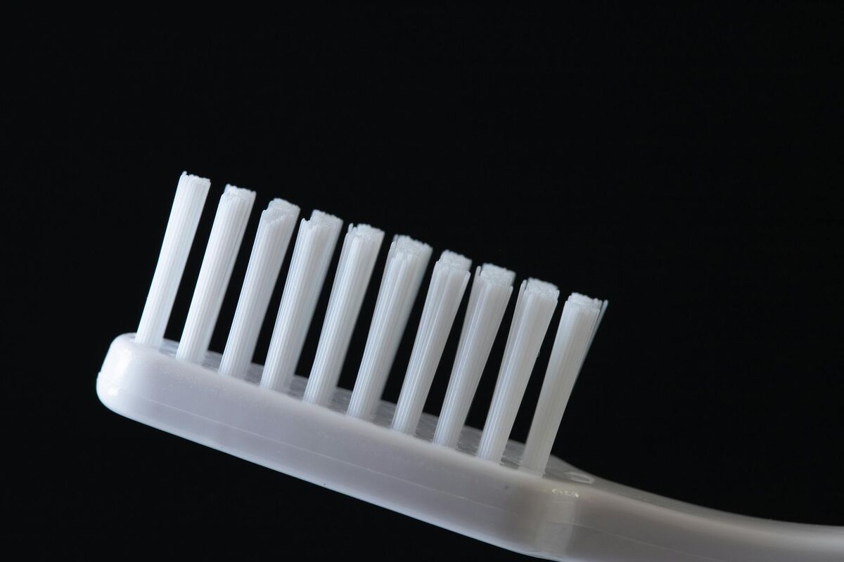 Soft Bristle Toothbrush for Sensitive Teeth White soft-bristle toothbrush on dark background for gentle sensitive teeth brushing