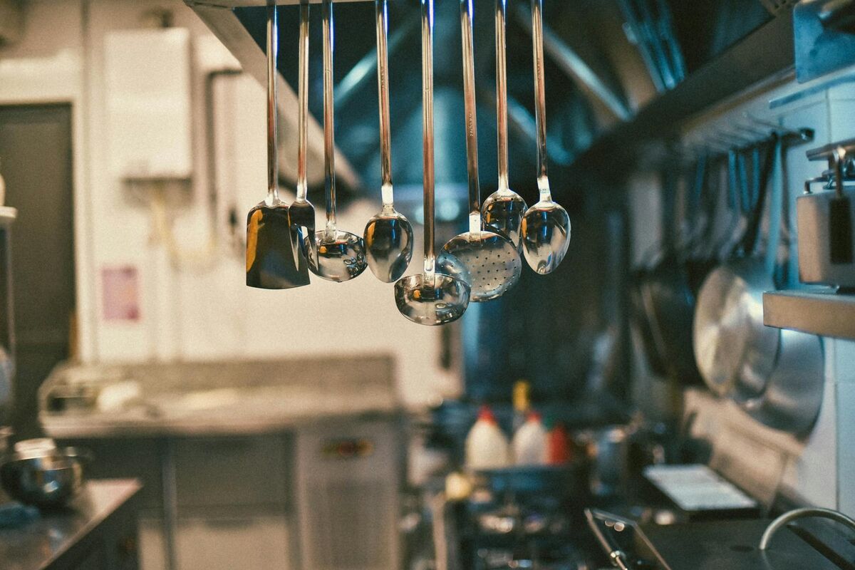Stainless steel kitchen utensils hanging in a modern kitchen